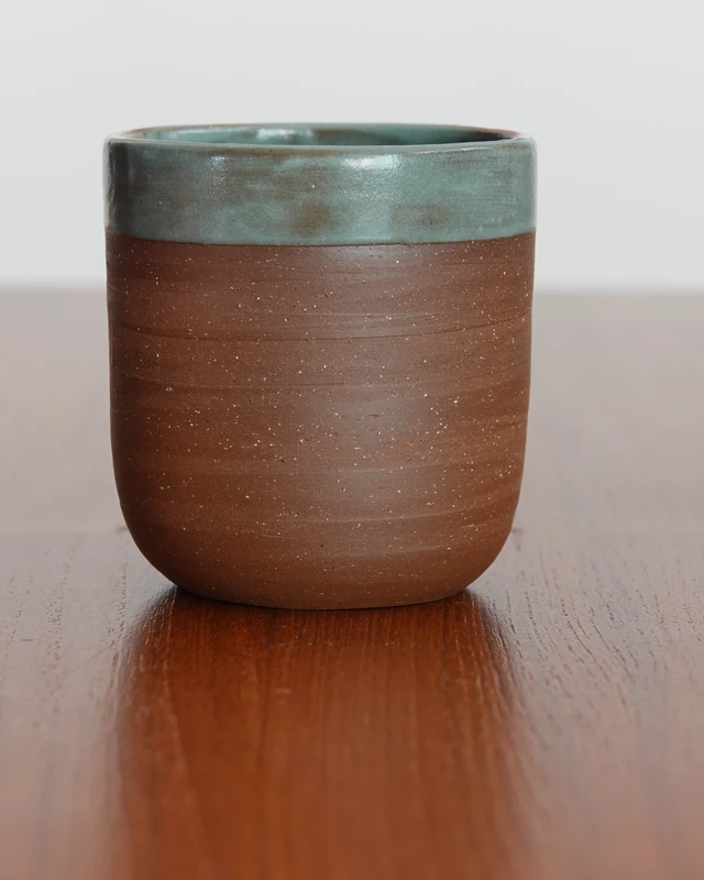 Tall brown cup with a blue-green glazed rim