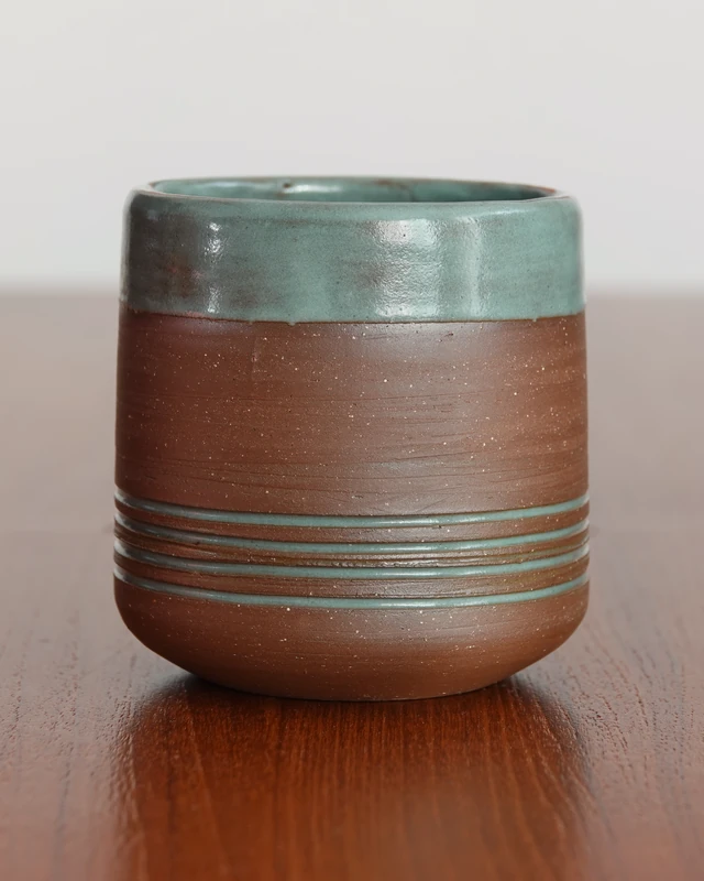 Brown cup with a glazed rim and fine horizontal rings